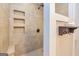 Modern tiled shower with built-in shelving, rainfall showerhead, and stylish fixtures at 130 Laurel Lake Rd, Tyrone, GA 30290