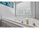 Close-up of a luxurious soaking tub with gold fixtures, offering a serene space for relaxation and rejuvenation at 40 Costleys Bridge Dr, Oxford, GA 30054