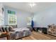 A charming bedroom features wood floors, a large window and playful decor at 40 Costleys Bridge Dr, Oxford, GA 30054