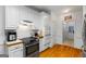 The kitchen features stainless steel appliances, white cabinets and tile backsplash, all illuminated by recessed lighting at 40 Costleys Bridge Dr, Oxford, GA 30054