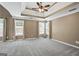 Primary bedroom featuring tray ceiling, large windows, and plush carpeting at 15 Livingston Way, Covington, GA 30016