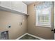 Functional laundry room with built-in cabinets and a view to the outdoors at 15 Livingston Way, Covington, GA 30016