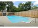 A backyard pool with concrete surround, wood privacy fence, and shed provides a relaxing oasis for summertime fun and entertainment at 15 Livingston Way, Covington, GA 30016