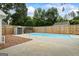 A pool with a concrete deck is surrounded by a wood fence, perfect for cooling off on hot days with room for lawn furniture at 15 Livingston Way, Covington, GA 30016