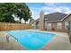 Inviting backyard pool enclosed by a fence, adjacent to the home's exterior and landscaping at 15 Livingston Way, Covington, GA 30016