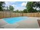 Sparkling in-ground pool, surrounded by a concrete patio and a wooden privacy fence, perfect for summer relaxation and entertaining at 15 Livingston Way, Covington, GA 30016