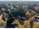 An aerial view shows a well-maintained neighborhood with tennis courts, a pool, and a pond surrounded by colorful trees at 355 Woodbyne Dr, Fayetteville, GA 30214