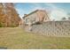 Backyard with grassy area, stone retaining wall and wooden deck at 355 Woodbyne Dr, Fayetteville, GA 30214