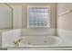 Close up of a bathtub with jets and tile surround at 355 Woodbyne Dr, Fayetteville, GA 30214