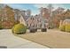 Stately brick two-story home with manicured lawn, mature trees and black shutters, perfect for a growing Gathering at 355 Woodbyne Dr, Fayetteville, GA 30214