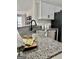 Close up of granite countertops, stainless steel dishwasher and black faucet in a modern kitchen at 355 Woodbyne Dr, Fayetteville, GA 30214