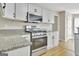 Well-lit kitchen featuring granite countertops, stainless steel appliances, and white cabinets at 355 Woodbyne Dr, Fayetteville, GA 30214