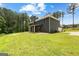Exterior elevation of home shows large backyard, concrete patios, and natural surroundings at 74 Riverwood Trl, Grantville, GA 30220