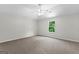 Bright bedroom with neutral walls, plush carpet, ceiling fan, and large window at 74 Riverwood Trl, Grantville, GA 30220