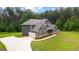 Exterior view shows home with three-car garage, manicured lawn, and well-maintained landscaping at 74 Riverwood Trl, Grantville, GA 30220