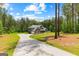 Two-story home featuring lush green lawn, a long driveway and wooded backyard at 74 Riverwood Trl, Grantville, GA 30220