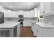 Bright kitchen features white cabinetry, stainless appliances, gray backsplash, and hardwood floors at 74 Riverwood Trl, Grantville, GA 30220