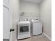 A bright laundry room features tile floors and white front load washer and dryer at 74 Riverwood Trl, Grantville, GA 30220