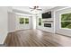 Bright living room with hardwood floors, ceiling fan, and fireplace beneath a wall-mounted TV at 74 Riverwood Trl, Grantville, GA 30220