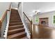 Inviting living room featuring a fireplace and hardwood floors, adjacent to a staircase at 74 Riverwood Trl, Grantville, GA 30220