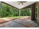 Covered patio with concrete flooring overlooking backyard with wooded area and decorative stone at 74 Riverwood Trl, Grantville, GA 30220