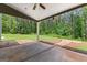 Covered patio features concrete flooring and wooded backyard with lush green grass at 74 Riverwood Trl, Grantville, GA 30220
