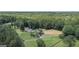 Aerial view showcasing the estate's house, horse arena, and surrounding woods at 135 Brookshire Dr, Fayetteville, GA 30215