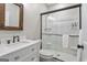 Modern bathroom features a vanity with marble countertop, framed mirror, and glass-enclosed shower at 135 Brookshire Dr, Fayetteville, GA 30215