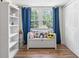 Bright bedroom features a window, a bench, and closet, with hardwood floors and white walls at 135 Brookshire Dr, Fayetteville, GA 30215