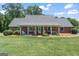 Charming brick home with a welcoming front porch, rocking chairs, and well-manicured lawn at 135 Brookshire Dr, Fayetteville, GA 30215