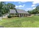 Exterior view showcasing the brick home, front porch, and a green lawn at 135 Brookshire Dr, Fayetteville, GA 30215