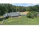 Exterior shot of the home featuring a large lawn and a horse paddock at 135 Brookshire Dr, Fayetteville, GA 30215