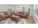 Open-concept living room with hardwood floors, neutral paint, and plush leather seating at 135 Brookshire Dr, Fayetteville, GA 30215