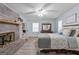 Spacious main bedroom featuring a decorative fireplace, fan, a large bed, and hardwood floors at 135 Brookshire Dr, Fayetteville, GA 30215