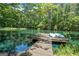 Picturesque dock on a tranquil pond with kayaks, surrounded by lush greenery at 135 Brookshire Dr, Fayetteville, GA 30215