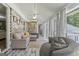 Sunroom with brick wall and neutral sectional, fan, and hardwood floors at 135 Brookshire Dr, Fayetteville, GA 30215