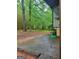 Image shows a section of the backyard with trees, bamboo, and a small concrete patio area at 106 Garden Trl, Stockbridge, GA 30281