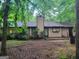 Backyard view featuring a single-Gathering home with a chimney and natural landscaping at 106 Garden Trl, Stockbridge, GA 30281