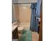 Bathroom with a shower-tub combo with a blue curtain, a toilet, and a sink at 106 Garden Trl, Stockbridge, GA 30281