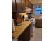 Kitchen with wood cabinets, white appliances, and a window with a floral curtain at 106 Garden Trl, Stockbridge, GA 30281