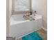 Modern white bathtub with a wood caddy and large window at 149 Pristine Dr, Locust Grove, GA 30248