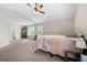 Spacious carpeted bedroom features a ceiling fan and natural light at 149 Pristine Dr, Locust Grove, GA 30248