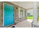 View of the inviting front porch with a vibrant teal door and brick accents at 149 Pristine Dr, Locust Grove, GA 30248