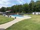 Wide view of a backyard with a pool, a seating area, shed, and lush lawn at 175 Bridgemill Dr, Covington, GA 30014