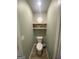 Clean half bath features wood look flooring and a decorative shelf at 175 Bridgemill Dr, Covington, GA 30014