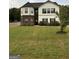 Charming two-story home features a manicured lawn and classic design with a brick and white facade and black shutters at 175 Bridgemill Dr, Covington, GA 30014