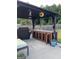 Outdoor bar area with covered seating, grill, curtains, and a sunflower decoration at 175 Bridgemill Dr, Covington, GA 30014