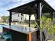 Covered outdoor bar with seating, stylish countertop, decorative wind chimes, and black curtains at 175 Bridgemill Dr, Covington, GA 30014