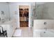 Spa-like bathroom featuring double sinks, a glass-enclosed shower, a soaking tub, and access to a walk-in closet at 2845 Long Shadow Ct, Snellville, GA 30078