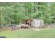 Outdoor shed with a lean-to, providing ample space for storage and projects in a lush, wooded backyard setting at 9706 Holly Hill Way, Jonesboro, GA 30238